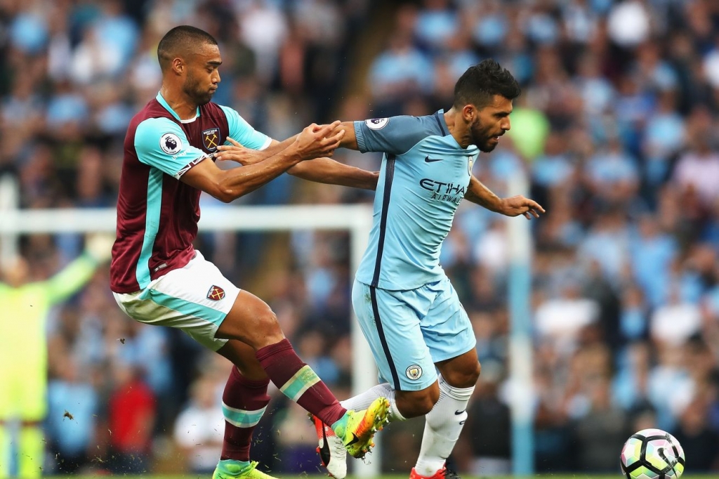 MANCHESTER ENGLAND- AUGUST 28 Sergio Aguero of Manchester City is challenged by Winston Reid of West Ham United during the Premier League match between Manchester City and West Ham United at Etihad Stadium