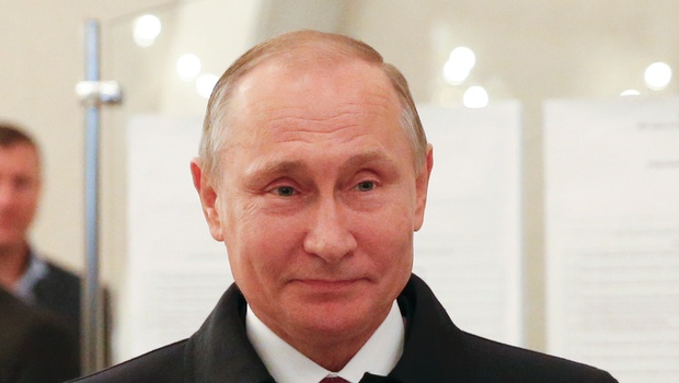 Russian President Vladimir Putin smiles at a polling station during a parliamentary election in Moscow Russia. | AP