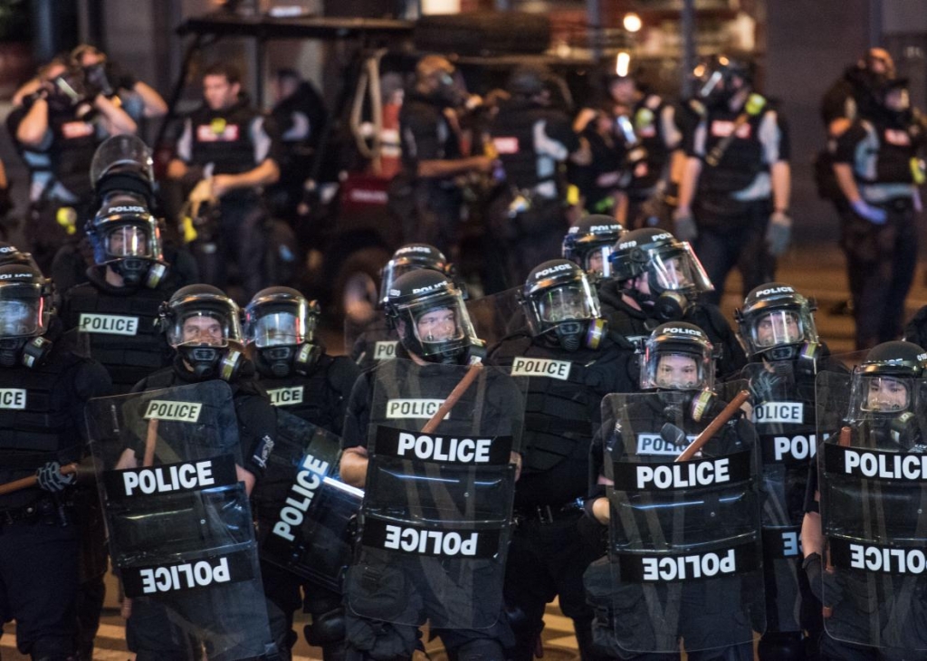 609664270-police-officers-in-riot-gear-hold-their-line-september