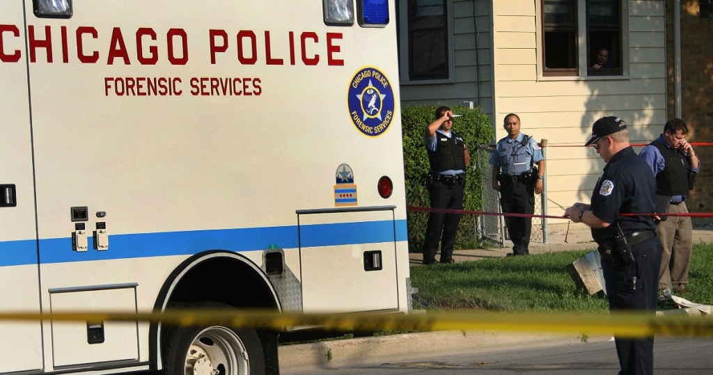 Police officers investigate a double homicide in the Kelvyn Park neighborhood