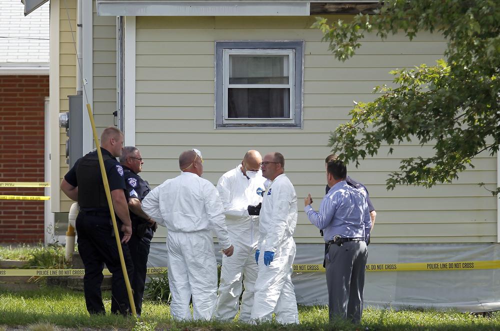 Police search a home where a woman reported being held captive and where bodies were found