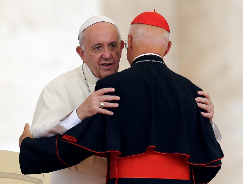 Pope Francis greets Cardinal Angelo Bagnasco at the end of his weekly audience at the Vatican