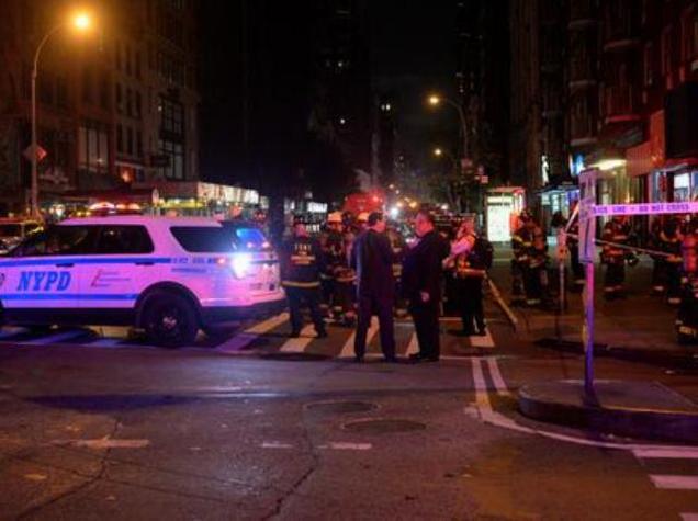 New York City police and firefighters stand near the site of a blast in which 29 people were injured in the Chelsea neighborhood of Manhattan New York on Saturday. CNN said law enforcement officials believe the