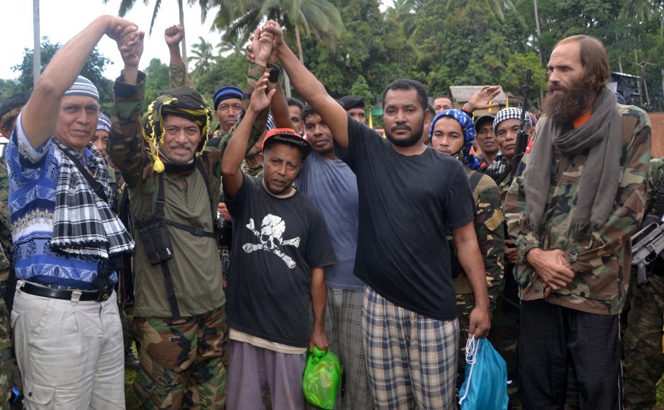 Released Norwegian hostage Kjartan Sekkingstad right watches MNLF chairman Nur Misuari second left raising the hands of the three released Indonesian hostages center after being turned over by Abu Sayyaf extremists in the Philippines. Pic AP