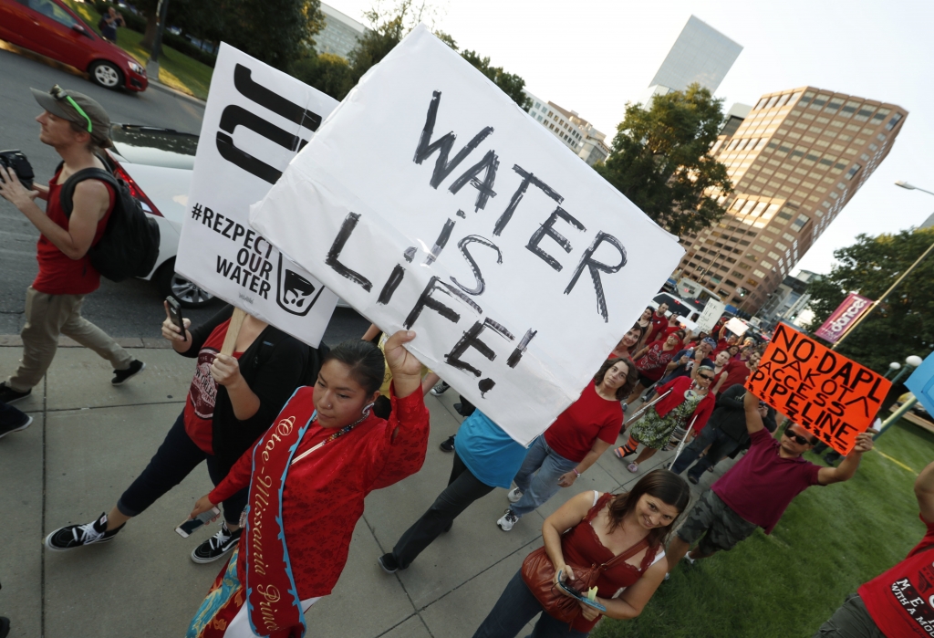 A line of protesters against the construction of the Dakota Access oil pipeline on the Standing Rock Reservation in North Dakota head to a unity rally on the west steps of the State Capitol late Thursday Sept. 8 2016 in Denver. (AP