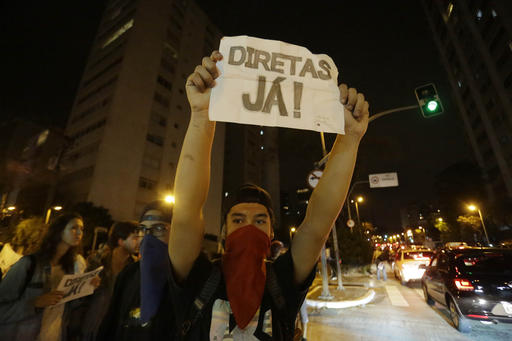 A man holds a sign that reads'Elections now during a protest against President Michel Temer in Sao Paulo Brazil Sunday Sept. 4 2016. Temer was sworn in as Brazil's new leader on Wednesday following the ouster of Preside