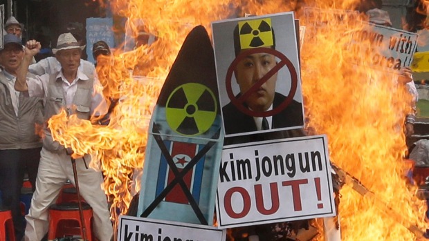 Protesters set fire to a defaced image of Kim Jong Un during a Seoul rally at the weekend