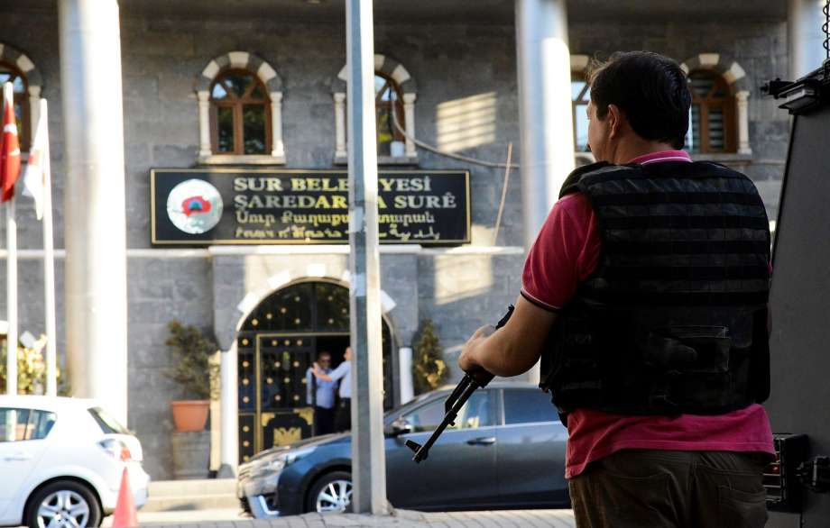 A police officer guards a municipal building in the city of Diyarbakir Turkey. On Sunday the government replaced 28 elected municipal and district mayors