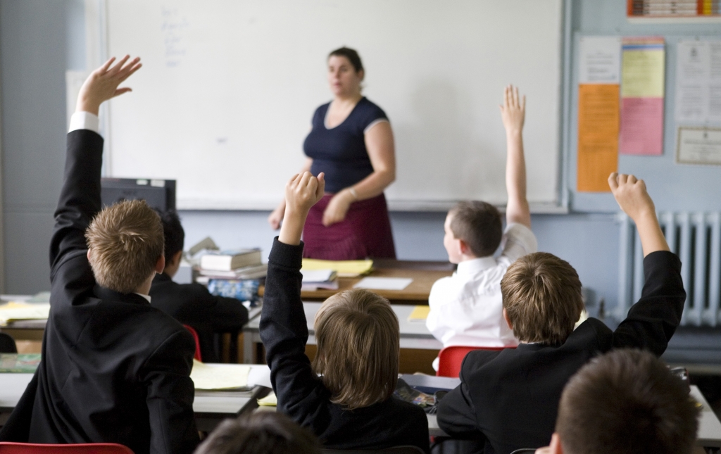 UNITED KINGDOM- JUNE 12 Pupils put their hands in the air to answer a question during a German lesson at Maidstone Grammar school Maidstone U.K. on Friday