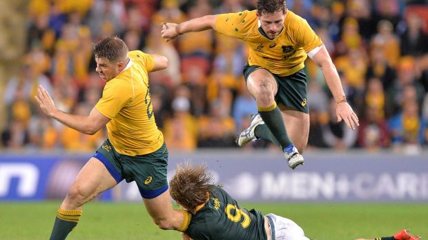 Putting in maximum effort Drew Mitchell attempts to break away as Bernard Foley hurdles clear against the Boks