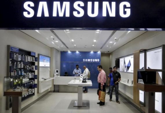 Customers at a Samsung mobile store in New Delhi look at several products on display