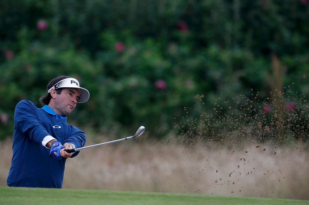 Bubba Watson hits out of a bunker on the first hole