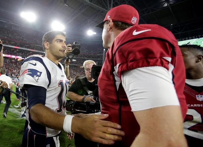 New England Patriots quarterback Jimmy Garoppolo and Arizona Cardinals quarterback Carson Palmer meet at mid field after an NFL football game Sunday Sept. 11 2016 in Glendale Ariz. The Patriots won 23-21