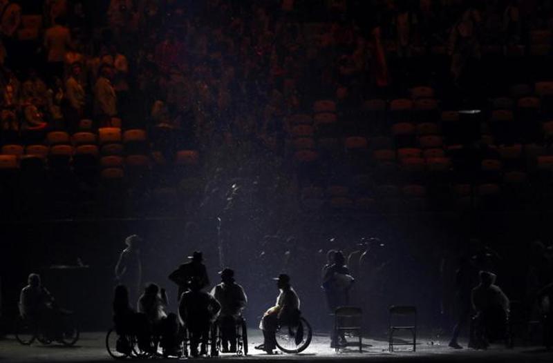 Rain falls on participants during the opening ceremony