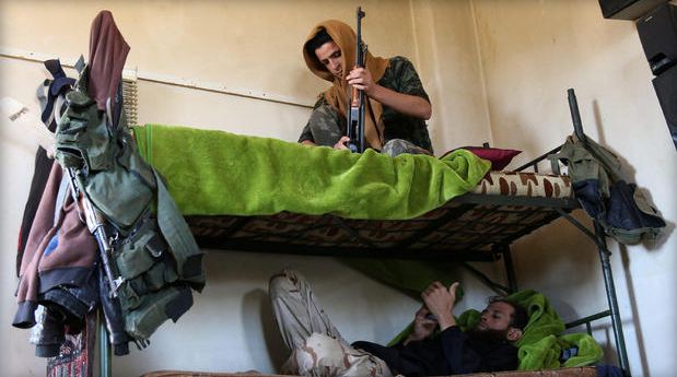 Rebel fighters rest on a double bed in Jubata al-Khashab in Quneitra countryside Syria