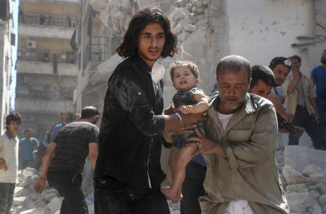 A Syrian civil defence member and a volunteer carry a little girl rescued from under the rubble of destroyed buildings following a reported airstrike on the rebel-held Salihin neighbourhood of the northern city of Aleppo