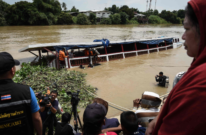 Rescue workers look for missing persons on a ferry which capsized the day before in the province of Ayutthaya Thailand on Monday. — AFP