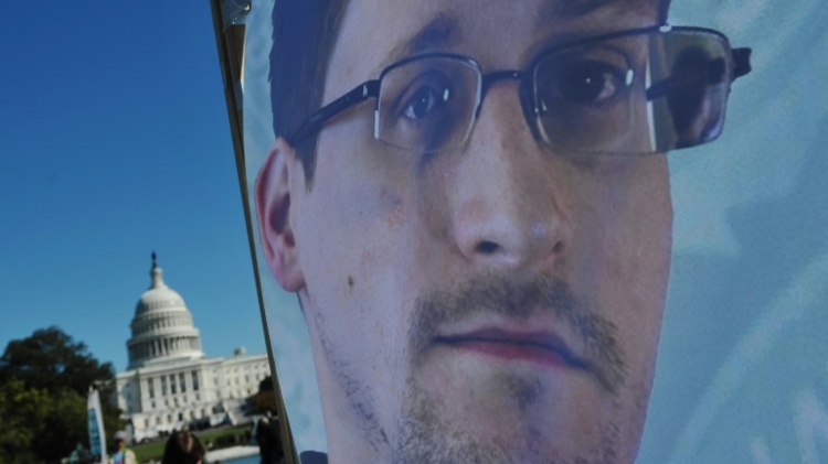 Une image d'Edward Snowden sur une banderole devant le Capitole américain le 26 octobre 2013 à Washington