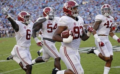 Alabama defensive lineman Jonathan Allen is escorted into the end zone by teammates as he returns a 75-yard interception of a Mississippi pass in the second half of an NCAA college football game Saturday Sept. 17 2016 in Oxford Miss. (AP