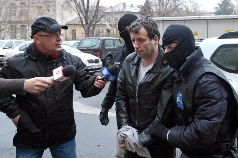 Lehel alleged hacker'Guccifer, is escorted by masked policemen in Bucharest after being arrested in Arad