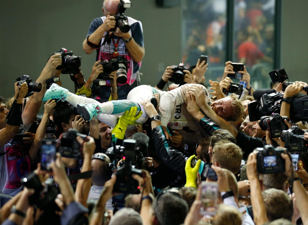 Rosberg- copying Hamilton’s crowd-surfing exploits at the British Grand Prix- leapt onto the hands of his mechanics in celebration Lynn Bo  EPA