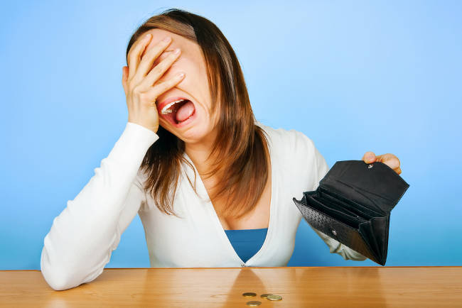 An upset woman with an empty wallet