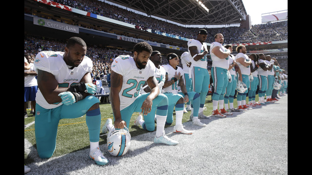 From left Miami Dolphins Jelani Jenkins Arian Foster Michael Thomas and Kenny Stills kneel during the singing of the national anthem before an NFL football game against the Seattle Seahawks Sunday Sept. 11 2016 in Seattle. (AP