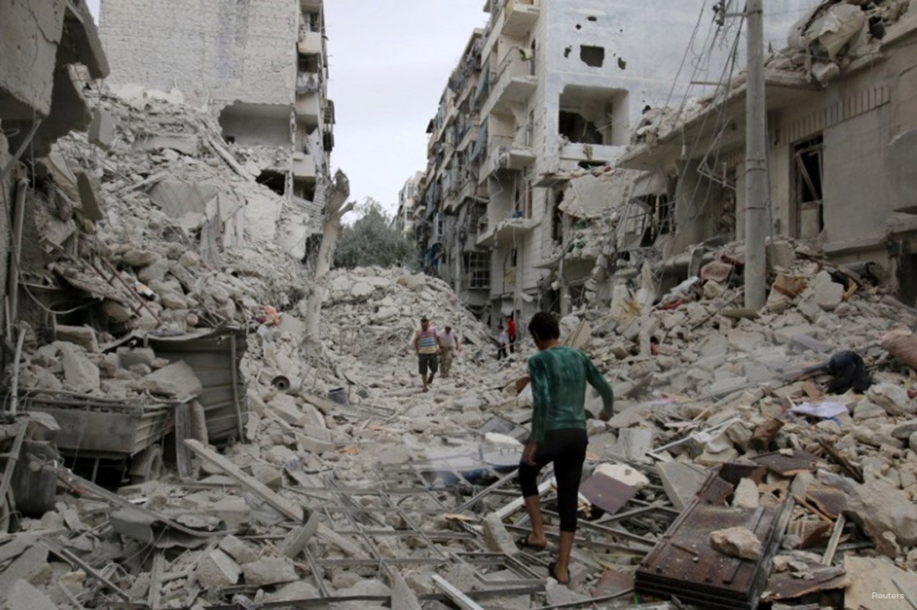 People inspect a damaged site after airstrikes on the rebel held Tariq al Bab neighbourhood of Aleppo Syria