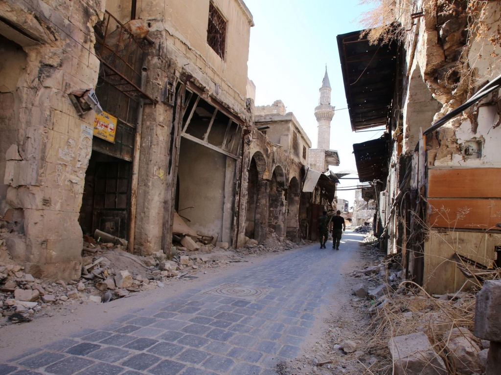 Syrian government soldiers walk in the damaged government-held side of Aleppo on Sept. 16. Initially U.N. officials had observed calm in war-ravaged Aleppo during the recent cease-fire but Saturday's violence in the country's eastern regions