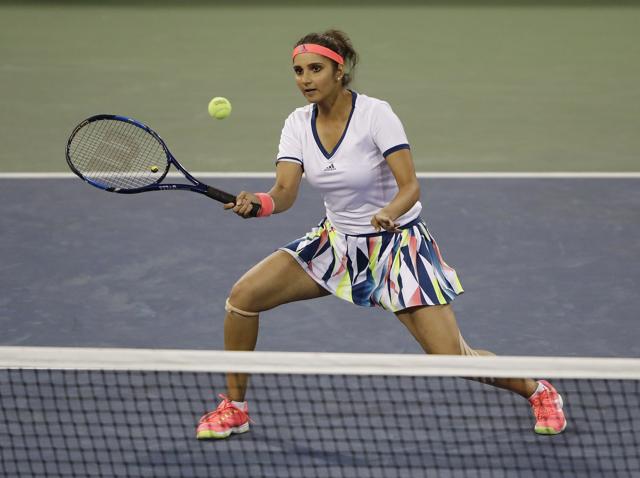 Sania Mirza of India returns a shot to Taylor Townsend and Donald Young during a mixed doubles match