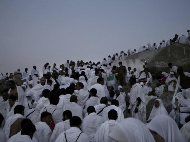 Muslim pilgrims make their way up on a rocky hill known as Mountain of Mercy on the Plain of Arafat during the annual hajj pilgrimage ahead of sunrise near the holy city of Mecca Saudi Arabia on Sunday