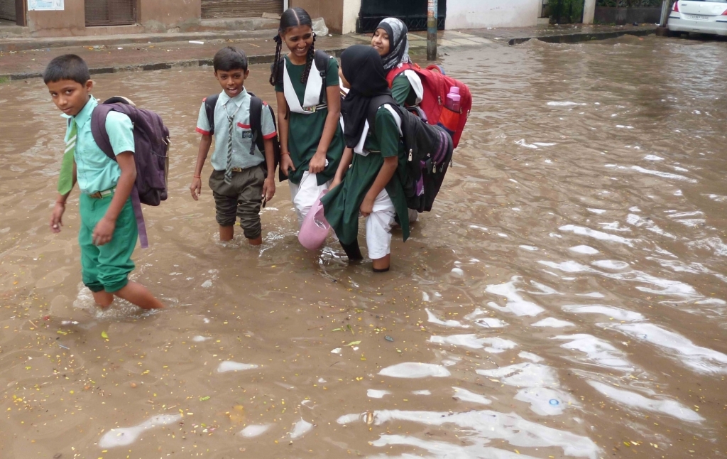 School children wade through knee-deep water in Hyderabad