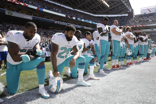 From left Miami Dolphins Jelani Jenkins Arian Foster Michael Thomas and Kenny Stills kneel during the singing of the national anthem before an NFL football game against the Seattle Seahawks Sunday Sept. 11 2016 in Seattle. (AP