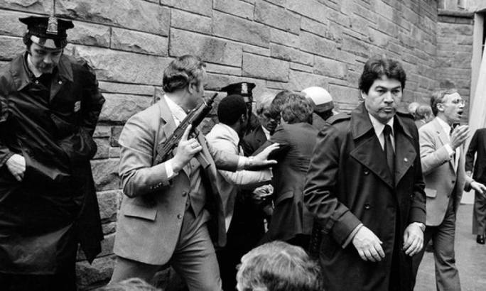 Secret service agents and police officers swarm Hinckley in 1981 after his failed assassination attempt on Ronald Reagan