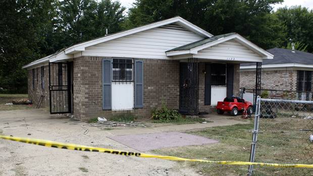 Security tape stretches across the driveway of a home where an early morning fire killed nine people in Memphis