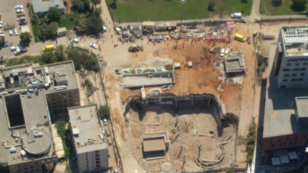 A fire brigade spokesman said part of the three-storey structure seen here in an aerial view had initially collapsed causing a crane to fall and bring down more of the partially-completed parking building