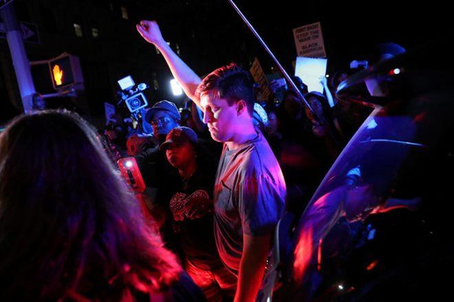 Dozens of protesters gathered after nightfall in a small park before setting off on a march through city streets chanting'Resist the police and calling for the video to be made public