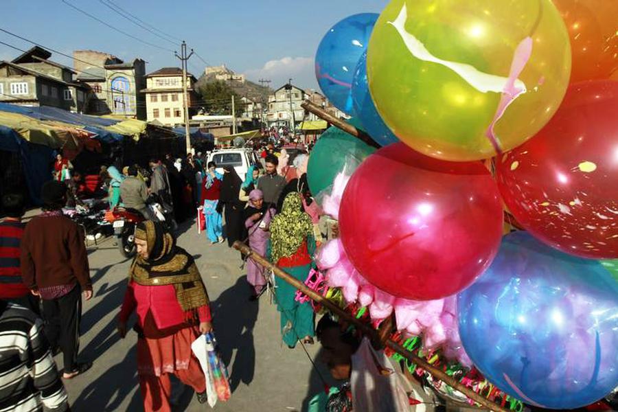 Shoppers walk in a market on the eve of Eid al Adha festival in Srinagar