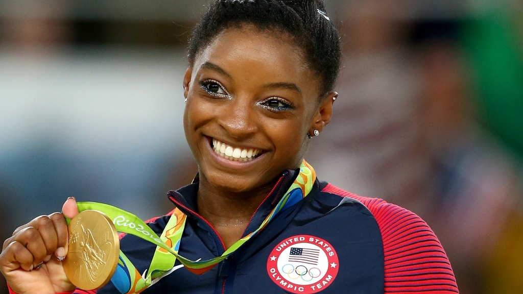 Gold medalist Simone Biles of the United States celebrates on the podium at the medal ceremony for the Women's Floor on Day 11 of the Rio 2016 Olympic Games at the Rio Olympic Arena