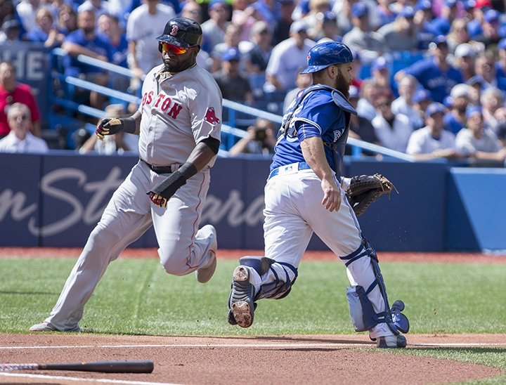 Boston Red Sox designated hitter David Ortiz heads to home plate past Toronto Blue Jays catcher Russell Martin during first inning American League baseball action in Toronto on Sunday