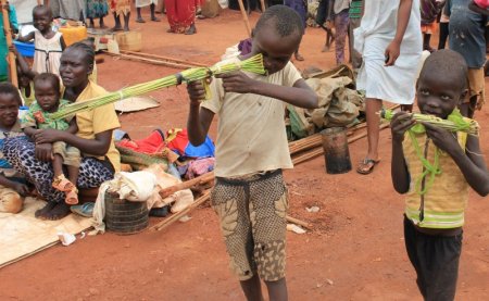 Martin Andrea 10 and a friend play with toy guns made from long grass reeds at a displaced persons camp protected by U.N. peacekeepers in Wau South Sudan