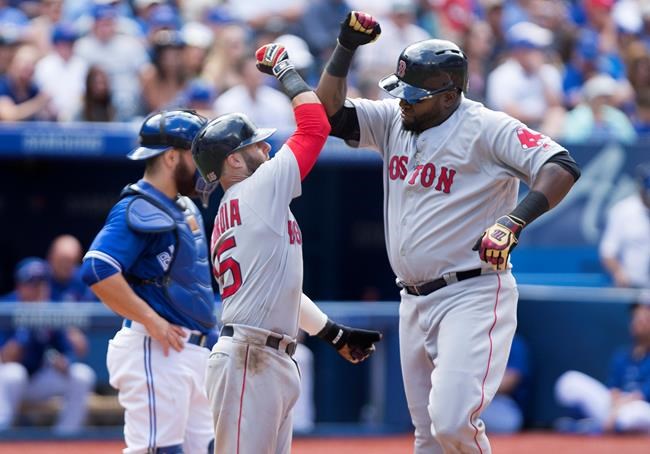 Boston Red Sox designated hitter David Ortiz celebrates his three-run homer in the 6th inning with teammate Dustin Pedroia during American League baseball action against the Toronto Blue Jays in Toronto on Sunday