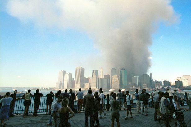 Spectators on the Brooklyn Heights Prominade watch the smoke from rise