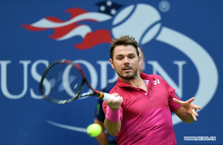 Stan Wawrinka of Switzerland returns a ball to Novak Djokovic of Serbia during the men