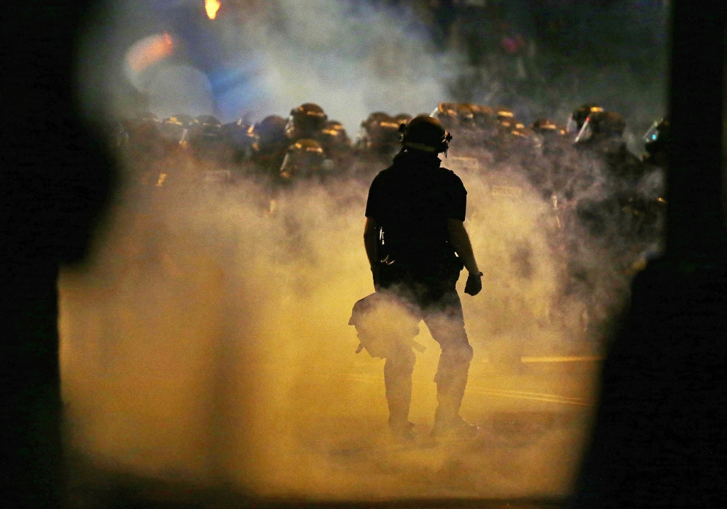 Police fire teargas as protestors converge on downtown following Tuesday's police shooting of Keith Lamont Scott in Charlotte N.C. Wednesday Sept. 21 2016. Protesters have rushed police in riot gear at a downtown Charlotte hotel and officers have