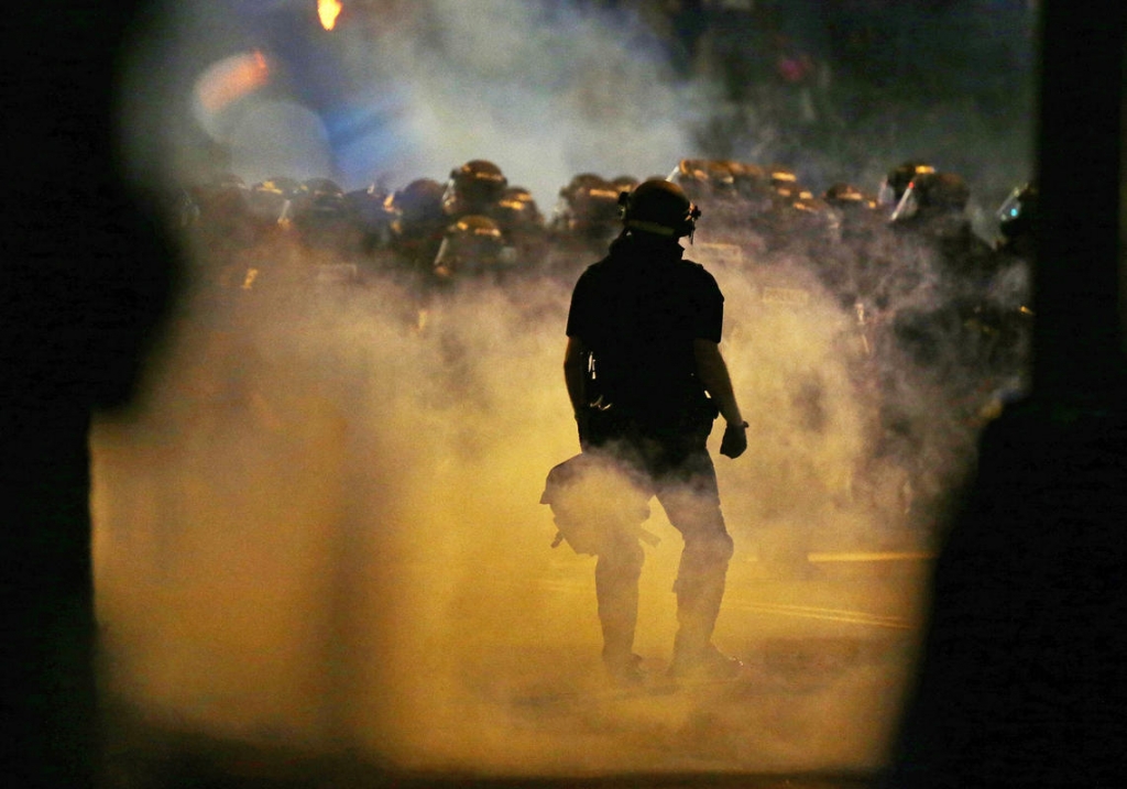 Police officers wearing riot gear block a road during protests after police fatally shot Keith Lamont Scott in the parking lot of an apartment complex in Charlotte North Carolina