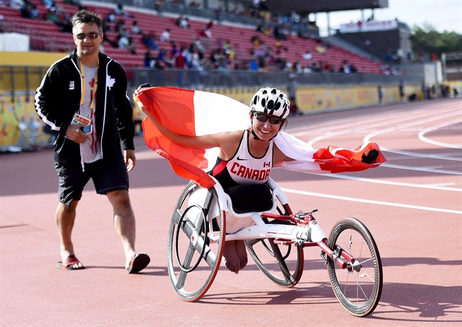 Michelle Stilwell shows off the Canadian flag after winning gold in the women's 100m T52 final during the Para Pan American Games in Toronto in August 2015