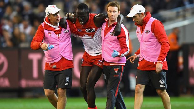 Strain Aliir Aliir is ushered off the field during the Swans preliminary final victory over the Cats at the MCG