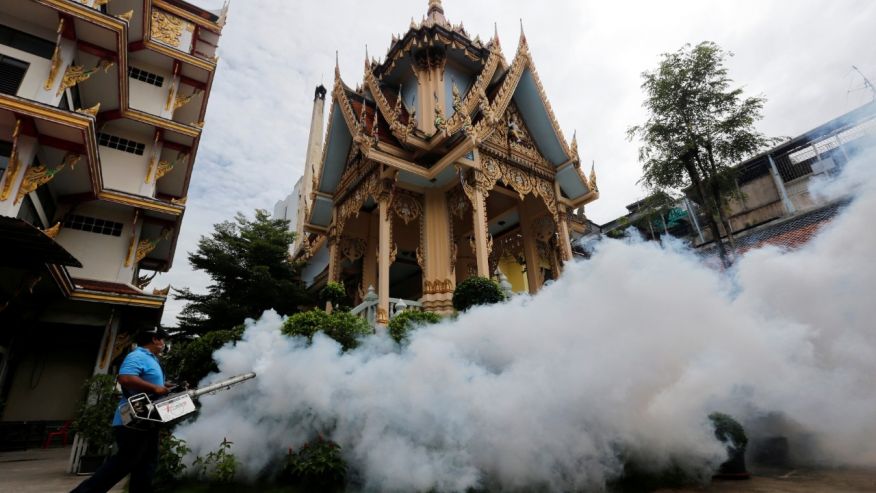 A city worker fumigates the area to control the spread of mosquitoes at a temple in Bangkok Thailand