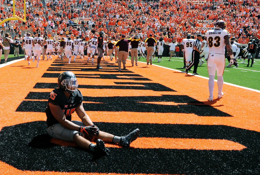 Oklahoma State linebacker Chad Whitener sits alone in the end zone while Central Michigan celebrates a last-second touchdown by receiver Corey Willis that gave the Chippewas a 30-27 win Saturday in Stillwater Okla